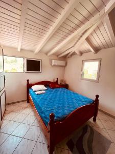 um quarto com uma cama grande e um cobertor azul em Villa de 3 chambres avec vue sur la mer jardin clos et wifi a Le Gosier a 2 km de la plage em Le Gosier