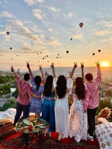 un grupo de personas con sus brazos en el aire con globos en Doors Of Cappadocia Special Cave Hotel, en Göreme