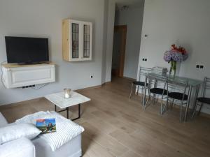 a living room with a couch and a table with a television at Apartamentos Meruelo in San Miguel de Meruelo