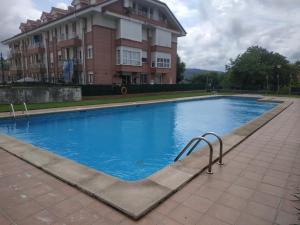 einem großen Pool vor einem Gebäude in der Unterkunft Apartamentos Meruelo in San Miguel de Meruelo