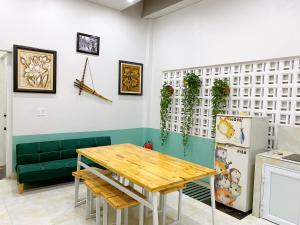 Thanh Sơn Homestay في كاو بانغ: غرفة طعام مع طاولة وأريكة خضراء