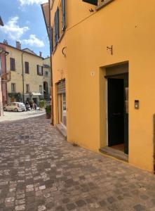 un callejón con un edificio amarillo con una puerta en LHE Beating Heart Casa Tiziana, en Cesena