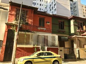 a yellow car parked in front of a building at Pousadinha Copacabana in Rio de Janeiro