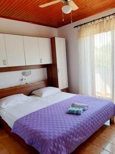 una camera con un letto e un piumone viola di House Branka a Kampor