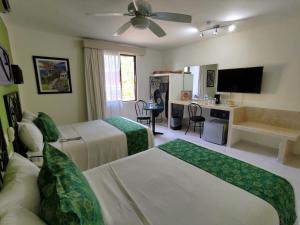 パレンケにあるHotel Maya Tulipanes Palenqueのベッド2台とリビングルームが備わるホテルルームです。