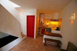 um quarto com uma porta vermelha e uma cozinha em Casa Amado, Aldeia da Pedralva em Vila do Bispo