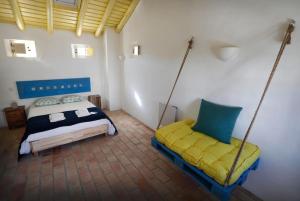 um quarto com uma cama e 2 baloiços em Casa Amado, Aldeia da Pedralva em Vila do Bispo