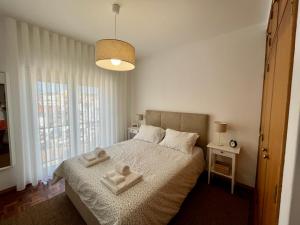 ein Schlafzimmer mit einem Bett mit zwei Handtüchern darauf in der Unterkunft Casa da Estação_São Martinho do Porto in São Martinho do Porto