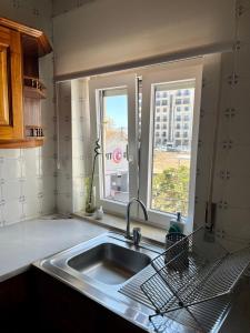 eine Küche mit einem Waschbecken und einem Fenster in der Unterkunft Casa da Estação_São Martinho do Porto in São Martinho do Porto