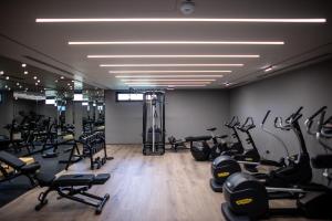 a gym with a lot of treadmills and machines at Prado Luxury Hotel in Himare
