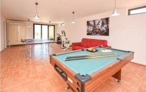 a living room with a pool table and a red couch at Stunning Home In Toffia With Outdoor Swimming Pool in Toffia