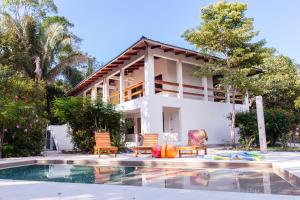 a house with a swimming pool in front of a house at Casa Rosada Nosara in Nosara