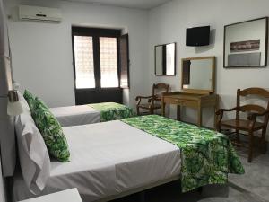 um quarto com duas camas, uma mesa e um espelho em La Casa en el Centro em Écija