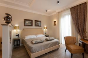 Schlafzimmer mit einem Bett, einem Schreibtisch und einem Stuhl in der Unterkunft Domus Clelia Paestum Antica Luxury rooms in Paestum