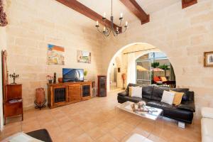 a living room with a couch and a tv at Ta Indri Holiday Home in Żebbuġ