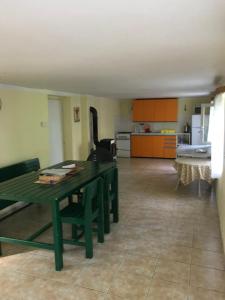 a living room with a green table and a kitchen at Chata Slapy Skalice 2 in Slapy +9 photos