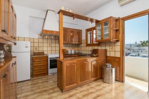 a kitchen with wooden cabinets and a white refrigerator at Granny's Yard in Adamas