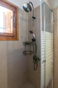 a shower with a shower head in a bathroom at Granny's Yard in Adamas