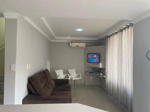 a living room with a couch and a table and chairs at Hotel San Carlos in Balneário Camboriú