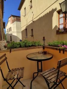 une table et deux chaises assises sur un balcon dans l'établissement Camere La Carbonaia, à Pienza