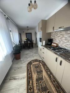 a kitchen with a rug in the middle of a room at Cazare Nely in Novaci-Străini