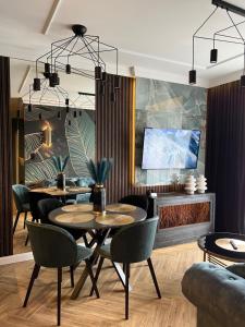 comedor con 2 mesas y sillas en Family & Business Sauna Tężnia Apartments No 10 VIP -Leśny nad Zalewem Cedzyna, Unikat SPA- 1 Bedroom with Private Sauna, Jacuzzi, Spectacular View Terrace, Parking, Catering Options, en Kielce