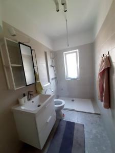 baño con lavabo y aseo y ventana en Apartment Riko - accomodation "with" the Adriatic sea, en Kampor