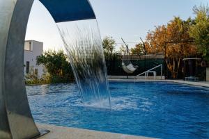 une fontaine dans une piscine avec balançoire dans l'établissement Apartment Levarda with private hydromassage pool, à Okrug Gornji