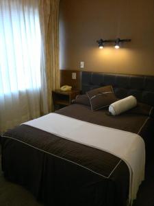 a bedroom with a large bed with a window at Hotel Flamingo Kristal in Irapuato
