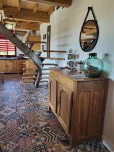 Habitación con escalera y espejo en la pared. en La ROSÉE des Cévennes Gîte 120m2 à 5min d'Anduze en Massillargues-Attuech