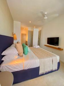 a bedroom with a large bed with a flat screen tv at Eastern Blue - Sea View Luxury Apartment in Poste Lafayette