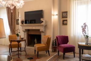 a living room with a fireplace and a tv at Domus Clelia Paestum Antica Luxury rooms in Paestum +29 photos