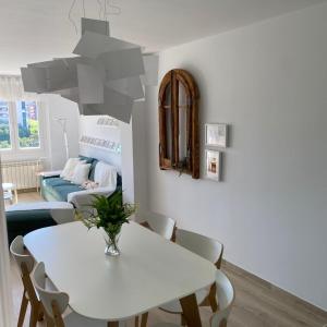 un comedor blanco con una mesa y sillas blancas en Apartamento completamente reformado en el casco antiguo con vistas al rio, en Balaguer