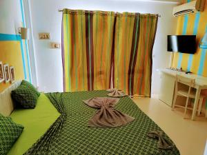 a green bed in a room with a curtain at Pensaò Big Game Maio in Vila do Maio