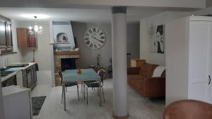 cocina y sala de estar con mesa y reloj en DIGIO house, en Camerata Picena
