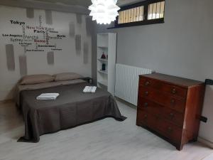 a bedroom with a bed and a dresser and a chandelier at DIGIO house in Camerata Picena