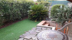 a garden with a table and a bench and grass at DIGIO house in Camerata Picena