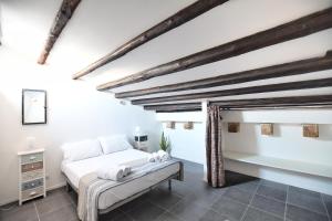 a bedroom with a white bed and wooden beams at iFlat Residenza Libertà ai giardini del centro in Palermo