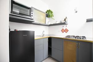 a kitchen with a black refrigerator and a microwave at iFlat Residenza Libertà ai giardini del centro in Palermo