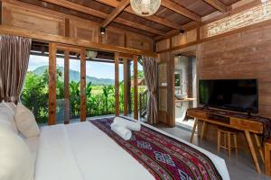 Kubu Sakian Villa في Silebeng: غرفة نوم بسرير كبير وتلفزيون بشاشة مسطحة