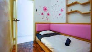 a small bed with a pink headboard in a room at Sakura Home in Batu Ferringhi +108 photos