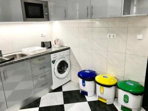 a kitchen with a washing machine and two trash cans at Sublime Yellow Bedroom in Lisbon