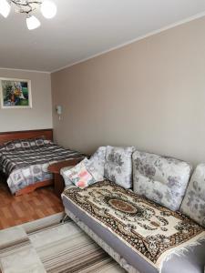 a living room with a couch and a bed at 1 комнатная квартира в самом центре с видом на сквер in Kostanay