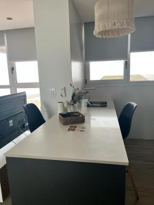 a kitchen counter with chairs and a table with flowers on it at Dpto con vista increible 102 in Mar del Plata