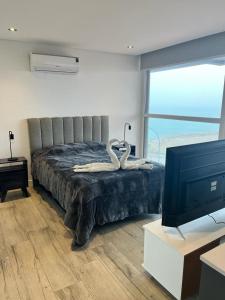 a bedroom with a large bed with a television at Dpto con vista increible 102 in Mar del Plata