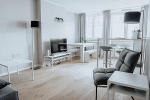 a white living room with a couch and a tv at 2-Zimmer City Apartment 57m² mit King Size Bett und Küche in Münster