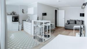 une cuisine blanche avec un comptoir et un canapé dans l'établissement 2-Zimmer City Apartment 57m² mit King Size Bett und Küche, à Münster