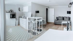 a white kitchen with a counter and a couch at 2-Zimmer City Apartment 57m² mit King Size Bett und Küche in Münster