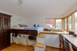 a bedroom with a bed and a desk and a kitchen at The Amsterdam Houseboat Family - de Jordaan in Amsterdam