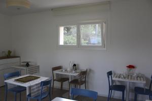 a dining room with two tables and chairs and a window at Tennis Rocchette Resort in Castiglione della Pescaia
